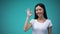 Cheerful asian woman showing ok sign, isolated on blue background, template