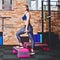 Cheerful athlete woman doing lunges with dumbbells