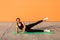 Cheerful athletic girl in tight sportswear, black pants and top, practicing yoga, doing side plank pose with leg lift