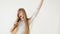 Cheerful attractive teen girl sing song holding comb like a microphone over white background.