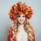 Cheerful autumn woman with makeup and long curly hair. Pretty model in autumn leaves crown