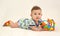 The cheerful baby holds a toy on a light background