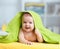 Cheerful baby lying under towel after bathing