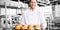 Cheerful baker holding tray of bread