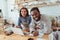 Cheerful baristas posing behind cafe counter