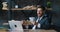 Cheerful bearded businessman in formal suit throwing money dollar bills having fun at desk in modern office alone