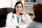 Cheerful beautiful doctor specialist at her hospital office with out of focus patient woman