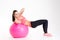 Cheerful beautiful fitness girl training abdominal muscles using fitball