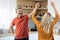 Cheerful beautiful middle aged spouses dancing together at kitchen