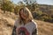 Cheerful beautiful woman with happy smile standing outdoors after a great healthy hike