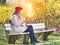 Cheerful Beautiful woman on a park bench chatting on smartphone