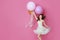 Cheerful Beautiful young girl in dress with sparkle and pink helium balloons enjoying birthday photoshoot dancing and smiling on p