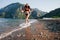 Cheerful bikini woman in Santa hat running carefree splashing water enjoying freedom