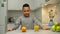 Cheerful black boy choosing between orange and glass of juice indoors