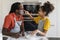 Cheerful Black Dad And Daughter Playing With Floor While Baking In Kitchen