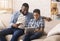 Cheerful Black Father Shopping Online With His Son Using Digital Tablet