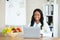 Cheerful black female dietitian using laptop pc, creating online weight loss program at modern clinic, free space