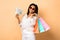 Cheerful Black Girl Holding Money And Shopper Bags In Studio