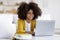 Cheerful black girl schooler doing homework, using computer