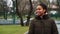 Cheerful black girl walking in park in dull weather