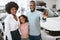 Cheerful black guy with his wife and daughter showing car key, happy over purchase of new vehicle at auto dealership