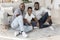 Cheerful Black Male Family Sitting On Floor At Home Posing To Camera