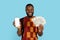 Cheerful Black Male Wearing Traditional African Costume Holding Blank Smartphone And Cash