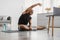 Cheerful Black Man Doing Side Bend Stretching Exercise At Home