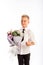 Cheerful blond fashionable boy gives bouquet and thumbs up on white studio background, delivery flowers, Spring Womens Day