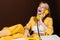 cheerful blonde girl talking by yellow vintage phone and laughing