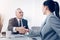 Cheerful boss and female office worker shaking hands