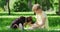 Cheerful boy playing with black and brown puppy at park