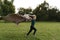 Cheerful boy running with a flying blanket in the park