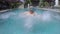 Cheerful boy splashing water in swimming pool