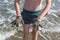 Cheerful boy teenager shows his hands in the healing healing mud from the sea