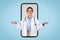 Cheerful brazilian doctor woman holding something invisible on her hands posing on huge smartphone screen, collage