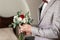 Cheerful bridegroom in elegant jacket. suit with a tie with flowers