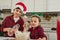 Cheerful brother and sister, adorable Caucasian children spend time together at home kitchen. Cute boy pours milk and baby girl