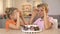 Cheerful brother and sister holding cake cherries front eyes, playing together