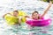 Cheerful brother and sister swimming in the pool