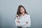 Cheerful brunette caucasian woman keeping hands crossed, looking angry