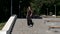 Cheerful brunette woman in black runs up the steps in the park. Slow motion