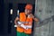 Cheerful builder smiling and holding carton cup of coffee