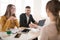 Cheerful business man with laptop and business woman in eyeglasses happily talking with applicant about work. Young