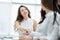 Cheerful businesswoman and client handshaking, sitting at the table