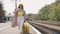 The cheerful and carefree girl traveler happily goes to meet rest and adventure. A young woman on a railway platform
