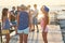 Cheerful and carefree group of friends hanging out at the sunny summer seaside on their vacation