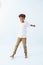 Cheerful carefree Indian boy swinging his arms against bluish white background