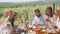 Cheerful carefree young adults spending time together during dinner outdoors in vacation home