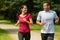 Cheerful Caucasian couple running outdoors